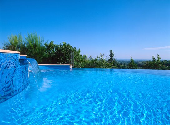 Outdoor flush edge swimming pool with blue sky on the background