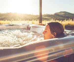 A woman relaxing in a outdoor hot tub