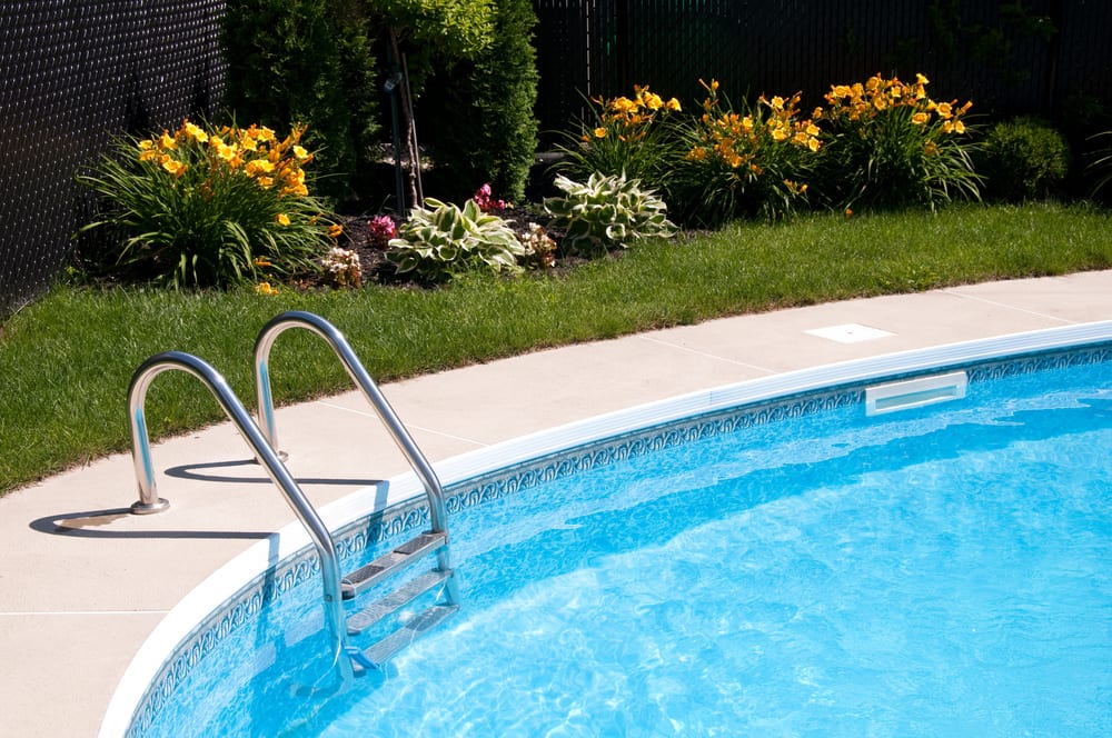 An outdoor backyard pool featuring above ground pool entry steps. If you have an above ground pool, or are thinking about installing one, you’ll need to consider which above ground pool entry steps to choose.